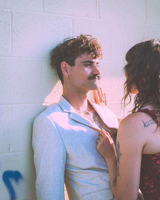 Intimate moment between a couple against a textured wall