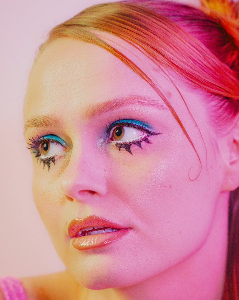 Close-up of a model with vibrant makeup and glossy lips.